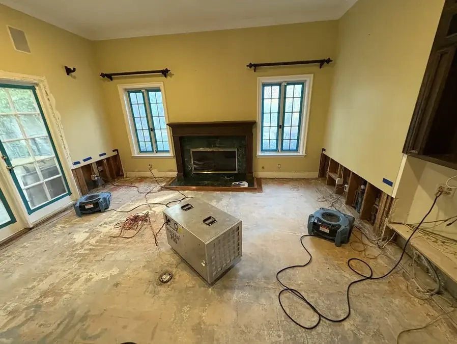 A dehumidifier running in a room with the lower walls flood-cut