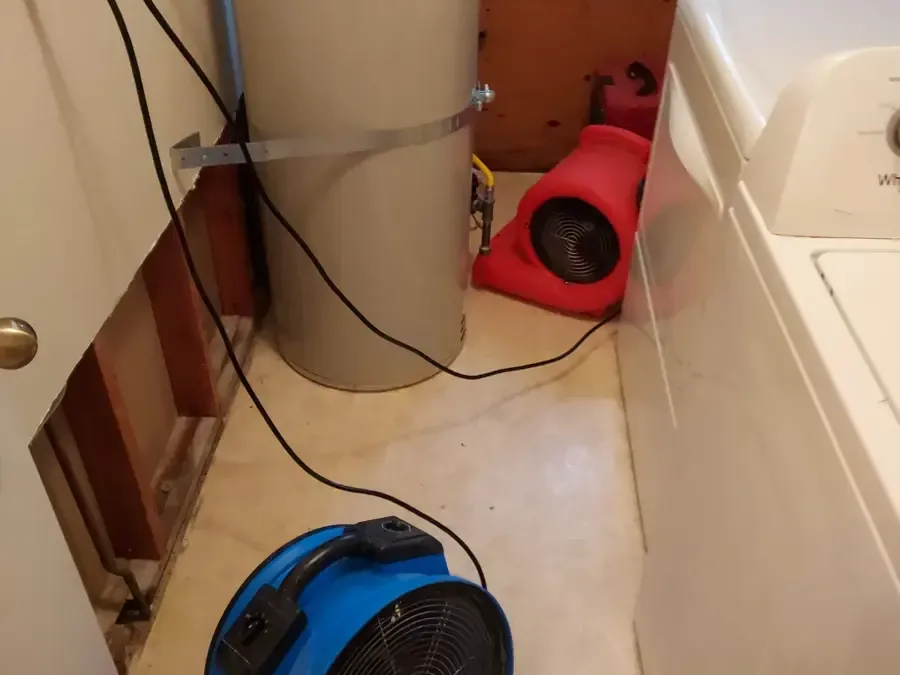 Air movers aimed at a laundry corner where the wall behind the washer was opened