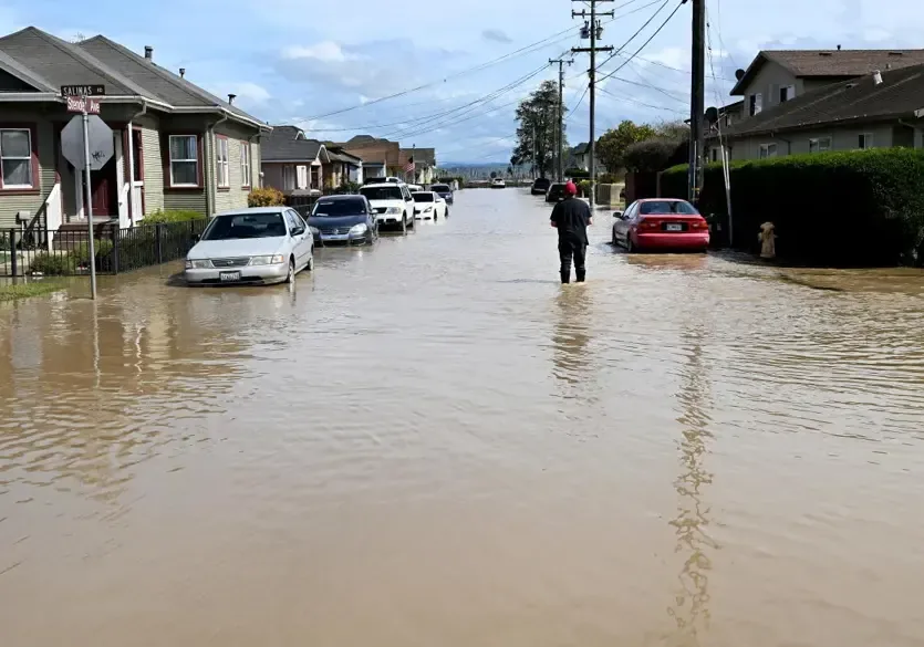 Storm runoff flooding a neighborhood street during heavy rain